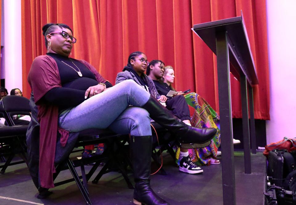 Audience members listen as police and community leaders meet Sunday for a community forum at the Tower Theatre.