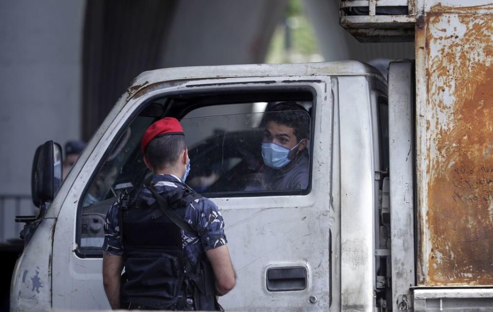 A member of the security forces talks to a truck driver at a checkpoint on the Dbayeh highway, north of the Lebanese capital Beiut. Source: Getty Images