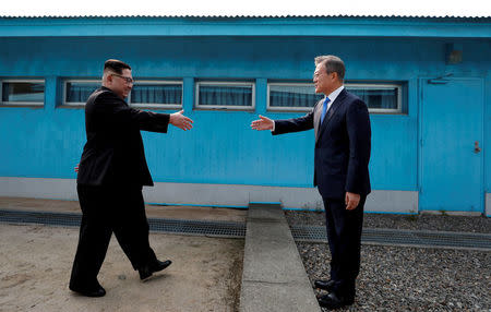 FILE PHOTO: South Korean President Moon Jae-in and North Korean leader Kim Jong Un (L) are about to shake hands on their first ever meeting at the truce village of Panmunjom inside the demilitarized zone separating the two Koreas, South Korea, April 27, 2018. Korea Summit Press Pool via Reuters/File Photo