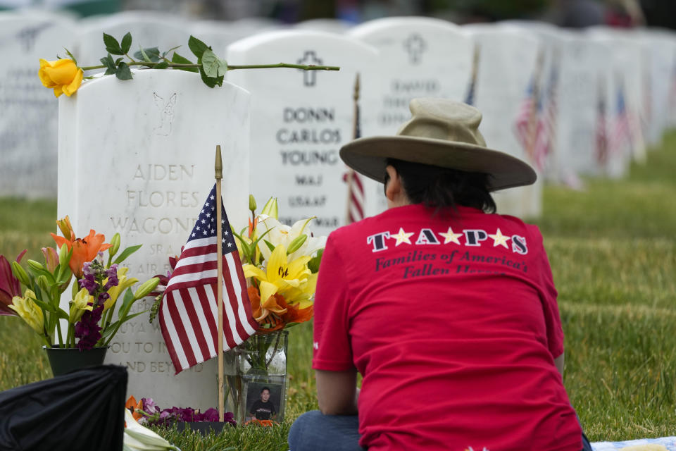 Ching Wagoner, of Roanoke, Va., visits the grave of her son U.S. Air Force Senior Airman Aiden Flores Wagoner in Section 60 at Arlington National Cemetery on Memorial Day, Monday, May 29, 2023, in Arlington, Va. (AP Photo/Alex Brandon)