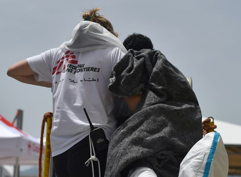 A migrant is helped by a member of Doctors Without Borders (MSF) arriving in the port of Cagliari, Sardinia