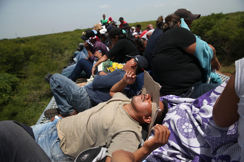 <p>Central American immigrants ride north on top of a freight train on Aug. 6, 2013, near Juchitlan, Mexico. Thousands of Central American migrants ride the trains, known as “la bestia,” or the beast, during their long and perilous journey north through Mexico to reach the U.S. border. Some of the immigrants are robbed and assaulted by gangs that control the train tops, while others fall asleep and tumble down, losing limbs or perishing under the wheels of the trains. Only a fraction of the immigrants who start the journey in Central America will cross Mexico completely unscathed — and all this before illegally entering the United States and facing the considerable U.S. border security apparatus designed to track, detain and deport them. (Photo: John Moore/Getty Images) </p>