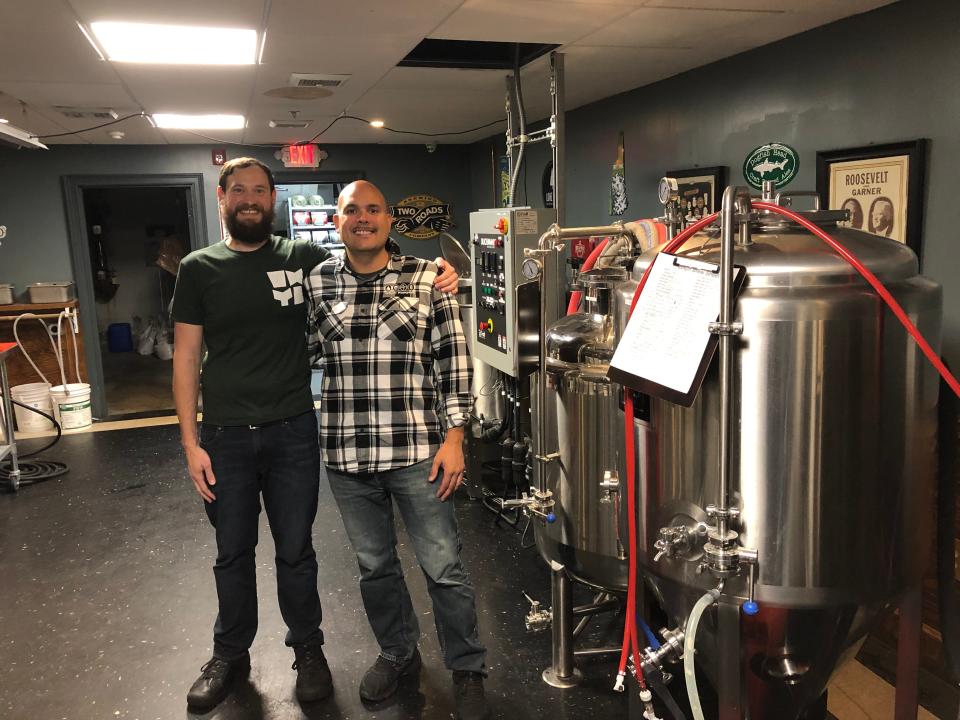 Owners Matt Barrett (left) and Alex Aviles stand in front of their two-barrel system in the basement bar and brew room at WHYM in Hampton. Plans are to break ground on a new brew house upstairs this spring which would house a much larger brewing system.