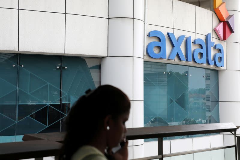 A woman walks past the Axiata headquarters building in Kuala Lumpur