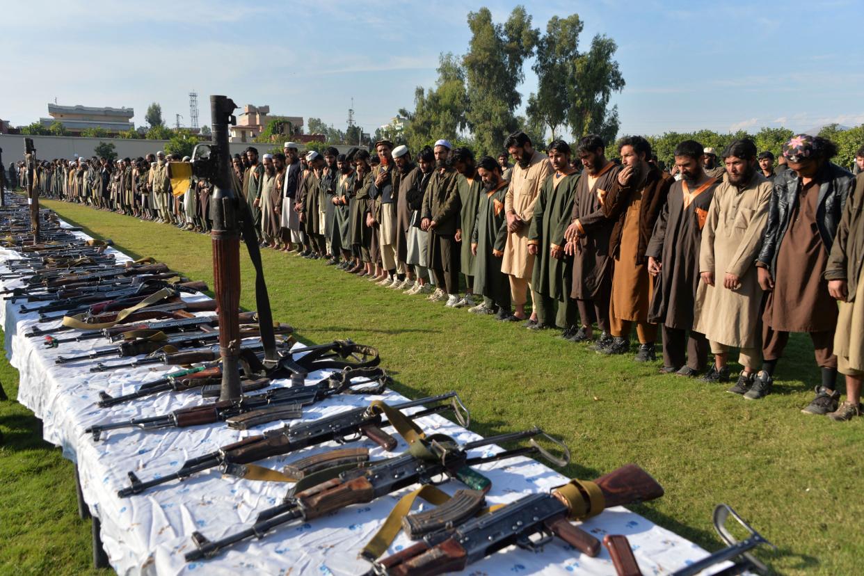 In this photograoh taken on November 17, 2019 members of the Islamic State (IS) group stand alongside their weapons, following they surrender to Afghanistan's government in Jalalabad, capital of Nangarhar Province. (Noorullah Shirzada/AFP via Getty Images)