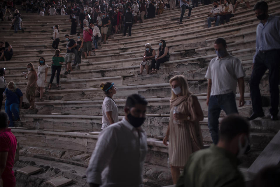 Spectators wearing protective face masks to to prevent the spread of the coronavirus leave the Odeon of Herodes Atticus in Athens, on Wednesday, July 15, 2020. The ancient theaters of Herodes Atticus in Athens and Epidaurus in the southern Peloponnese area have reopened for performances with strict seating limits and public health safety guidelines. (AP Photo/Petros Giannakouris)