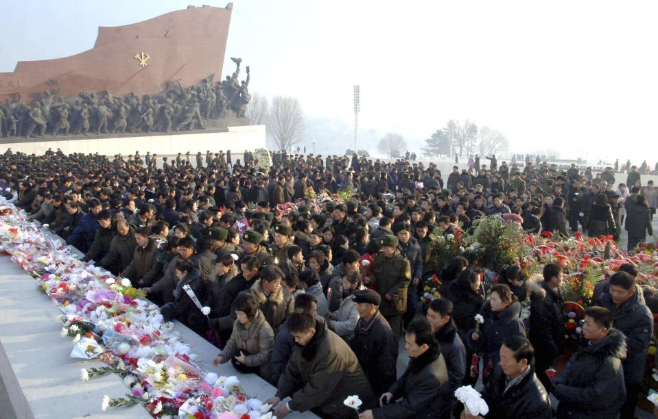 North Koreans offer flowers in front of statues of North Korea's founder Kim Il Sung and former leader Kim Jong Il at Mansudae hill in Pyongyang