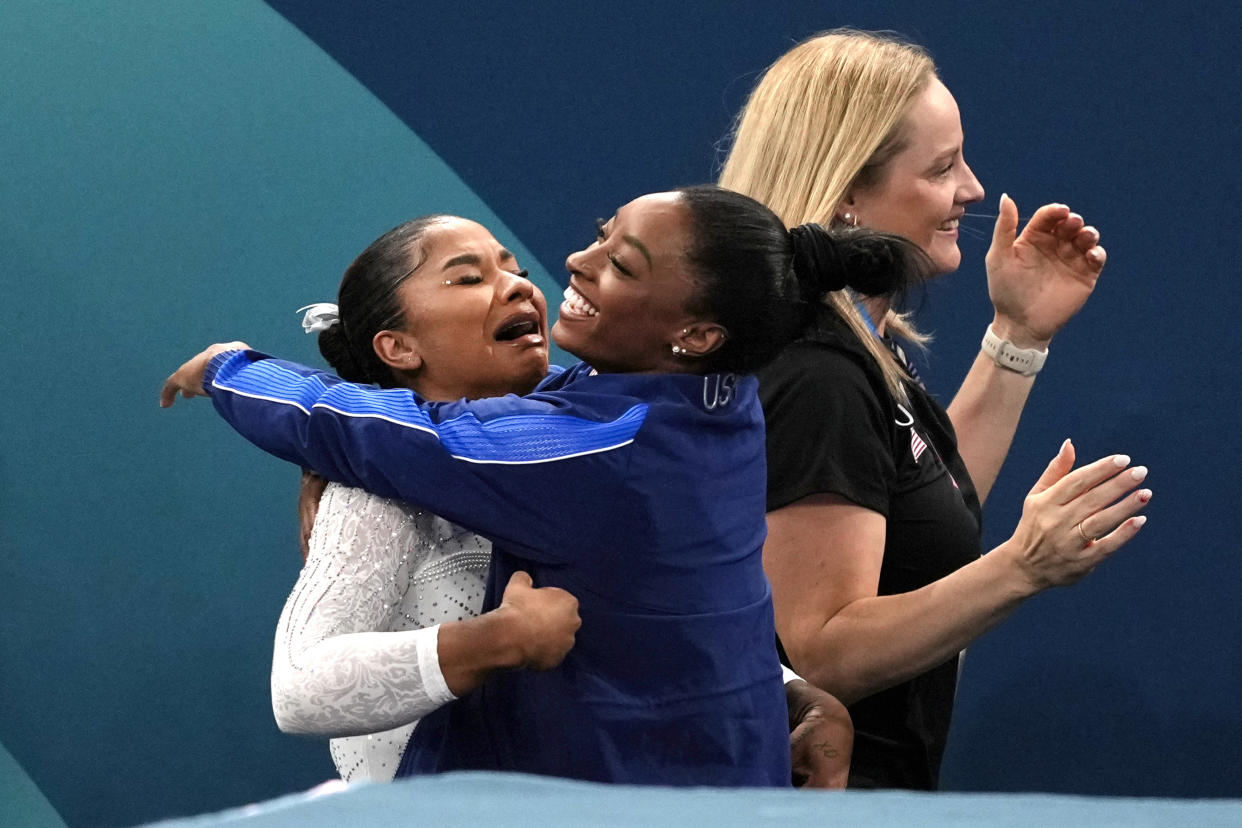 Jordan Chiles, left, of the United States, gets a hug from teammate Simone Biles after realizing she won the bronze medal during the women's artistic gymnastics individual floor finals at Bercy Arena at the 2024 Summer Olympics, Monday, Aug. 5, 2024, in Paris, France. (AP Photo/Francisco Seco)