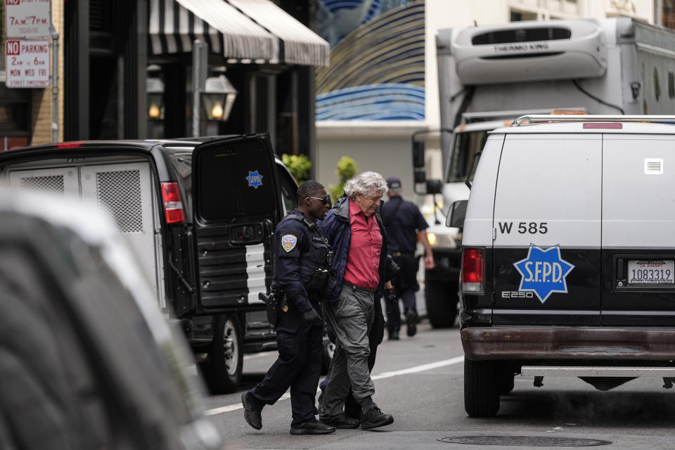 A pro-Palestinian demonstrator is escorted to a police vehicle outside a building housing the Israeli Consulate in San Francisco, Monday, June 3, 2024. Police on Monday arrested pro-Palestinian demonstrators who occupied the lobby of the building that houses the Israeli Consulate. (AP Photo/Jeff Chiu)