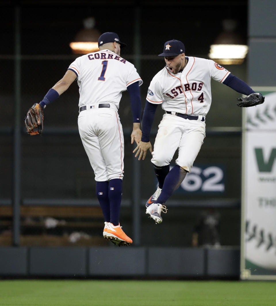 Houston Astros' Carlos Correa (1) and George Springer (4) celebrate their win over Cleveland Indians in Game 2 of a baseball American League Division Series, Saturday, Oct. 6, 2018, in Houston. (AP Photo/David J. Phillip)