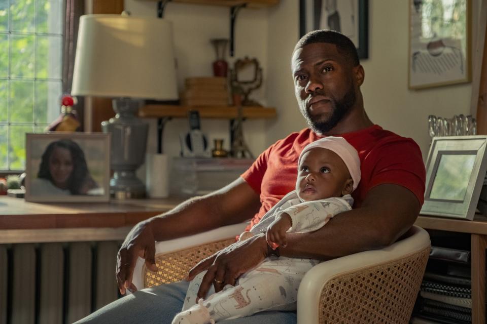 Kevin Hart sitting with baby.