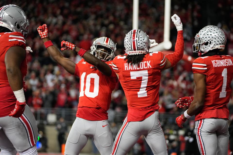 Nov 18, 2023; Columbus, Ohio, USA; Ohio State Buckeyes cornerback Jordan Hancock (7) and cornerback Denzel Burke (10) celebrate an interception by Hancock during the second half of the NCAA football game against the Minnesota Golden Gophers at Ohio Stadium. Ohio State won 37-3.