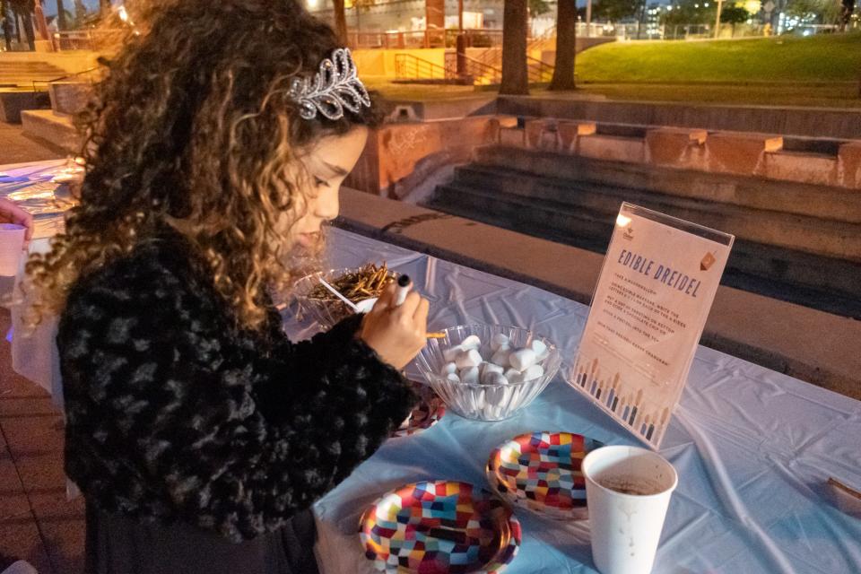 Aya Razon makes an edible dreidel at the Chanukah celebration on  Nov. 28, 2021, in Phoenix.