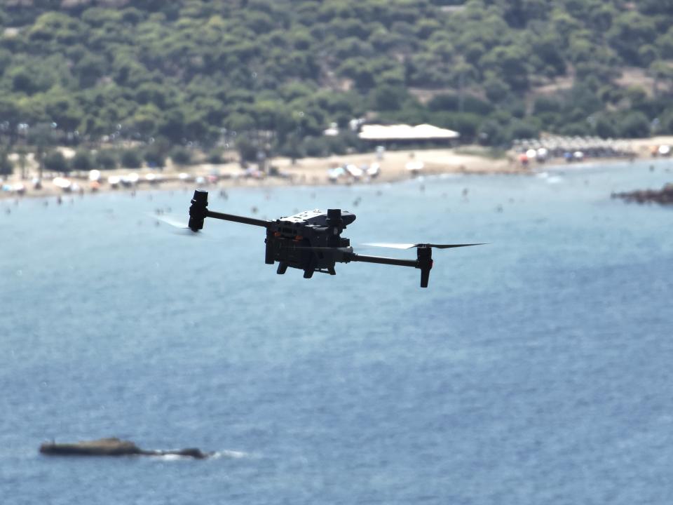 A long-range drone equipped with thermal imaging cameras and a sophisticated early warning system patrols over Kavouri beach and nearby woodland, in southern Athens, Greece, Thursday, Aug. 17, 2023. Greece is plagued by hundreds of wildfires each summer. To protect their area from potentially deadly blazes, a group of residents from a suburb in northern Athens have joined forces to hire a company using long-range drones equipped with thermal imaging cameras and a sophisticated early warning system to catch fires before they can spread. (AP Photo/Thanassis Stavrakis)