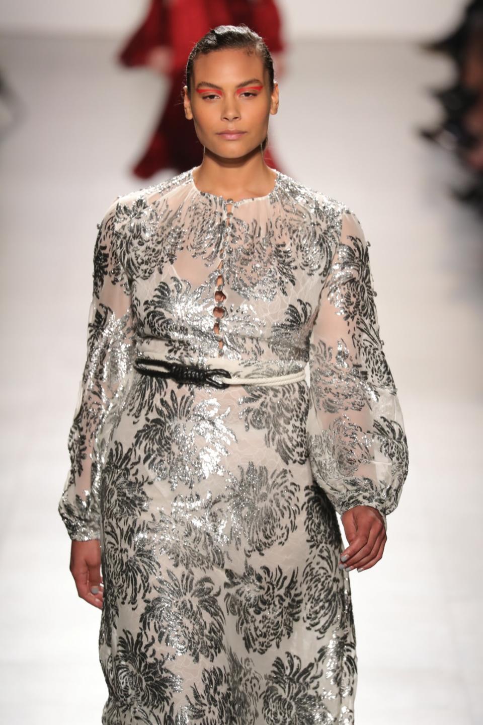 Another plus-size model wears a silver, sparkly brocade dress at Prabal Gurung.