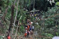 Malaysian emergency services personnel work to rescue passengers after a bus carrying tourists and local residents fell into a ravine near the Genting Highlands, about an hour's drive from Kuala Lumpur on August 21, 2013. At least 37 people are confirmed dead