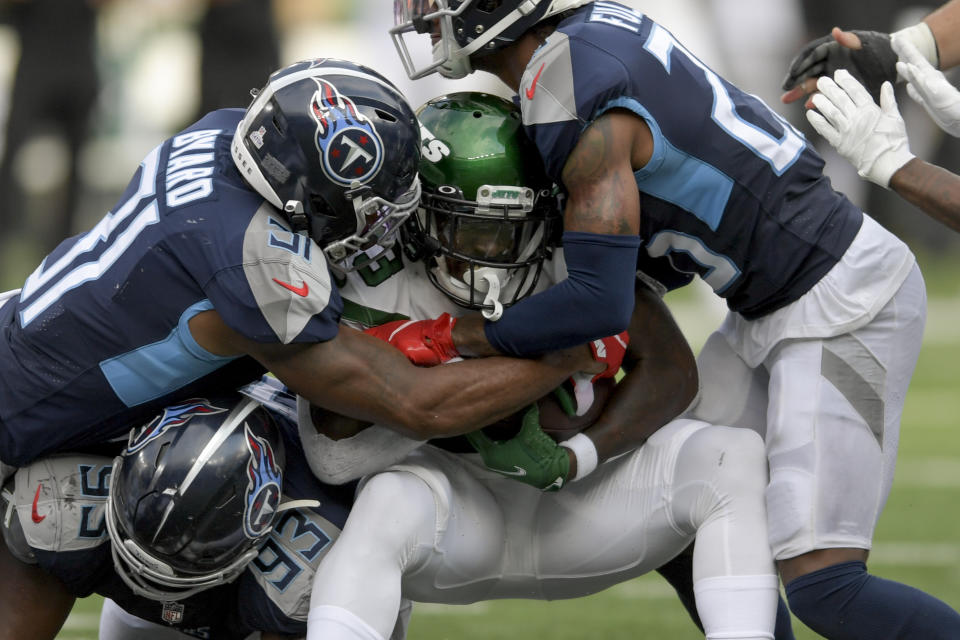 New York Jets running back Tevin Coleman, center, is tackled by Tennessee Titans free safety Kevin Byard (31) during overtime of an NFL football game, Sunday, Oct. 3, 2021, in East Rutherford, N.J. (AP Photo/Bill Kostroun)