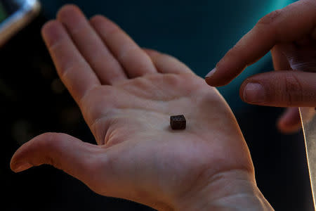 A member of the Association for the Recovery of Historical Memory (ARMH) shows a handmade dice found in the grave of Eugenio Molina Morato who was shot in 1939 by forces of dictator Francisco Franco in Guadalajara's cemetery, Spain, May 31, 2017. REUTERS/Juan Medina