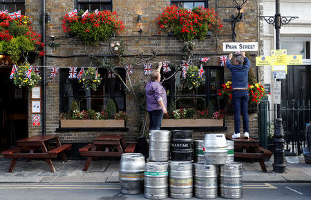 People decorate a pub with Union Flag bunting a day ahead of the royal wedding between Princess Eugenie and Jack Brooksbank in Windsor, Britain, October 11, 2018. REUTERS/Darren Staples