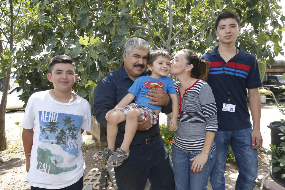 From left, Roman, Ruben, Rafael, Katy, and Ruben, pose for an photo in front of their house in Tucson, Ariz., on Tuesday, Sept. 4, 2018. Moroyoqui, 45, entered the country with authorization 16 years ago but then overstayed his visa, not wanting to return home because of the lack of opportunity there. He has four U.S. citizen children and said he has been a faithful taxpayer. “I feel great respect and love for this country,” he said. (AP Photo/Rick Scuteri)