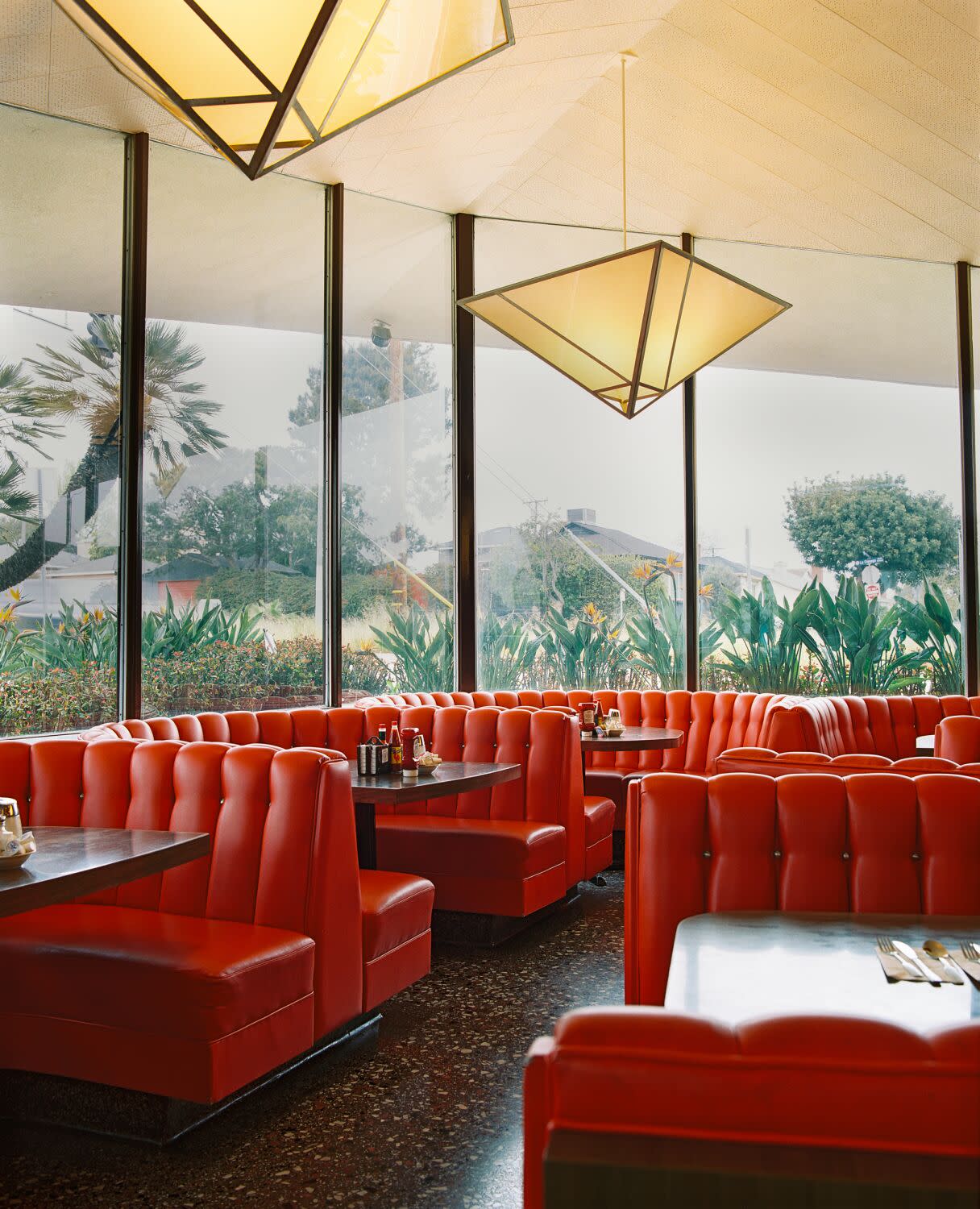 A photograph of the bright red booths at Pann's Restaurants, floor-to-ceiling glass windows.