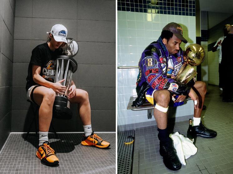 Caitin Clark recreates a 2001 photo of Kobe Bryant with a trophy. Both players have their heads down and serious expressions.