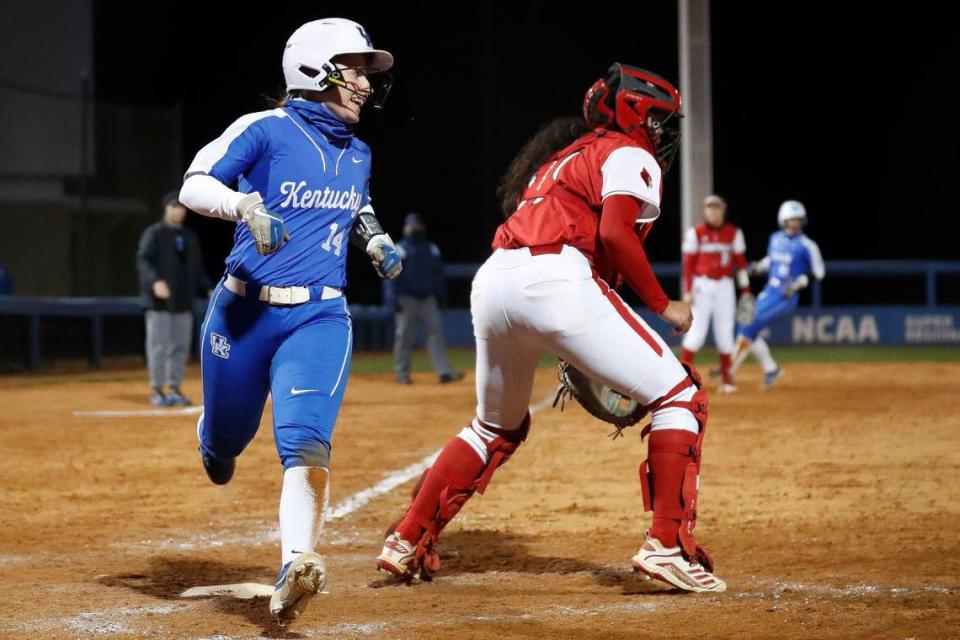 Kentucky outfielder Jaci Babbs (14) scores the game-winning run past Louisville catcher Rebecca Chung (37) on Wednesday.