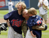 <p>United States Army Master Sgt. Rob Buresh, center, hugs his daughters Annie, left, and Alex after he made a surprise visit home from Afghanistan before a baseball game between the Minnesota Twins and the Detroit Tigers, Sunday, May 27, 2012, in Minneapolis. (AP Photo/Paul Battaglia) </p>