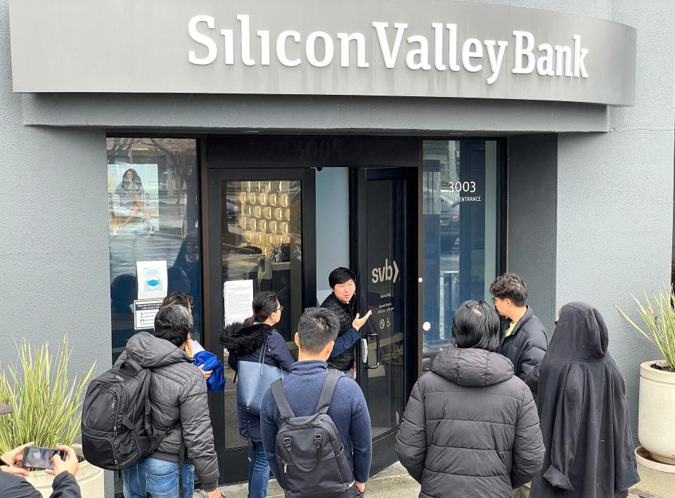 A worker tells people that the Silicon Valley Bank headquarters is closed on March 10, 2023, in Santa Clara, Calif.