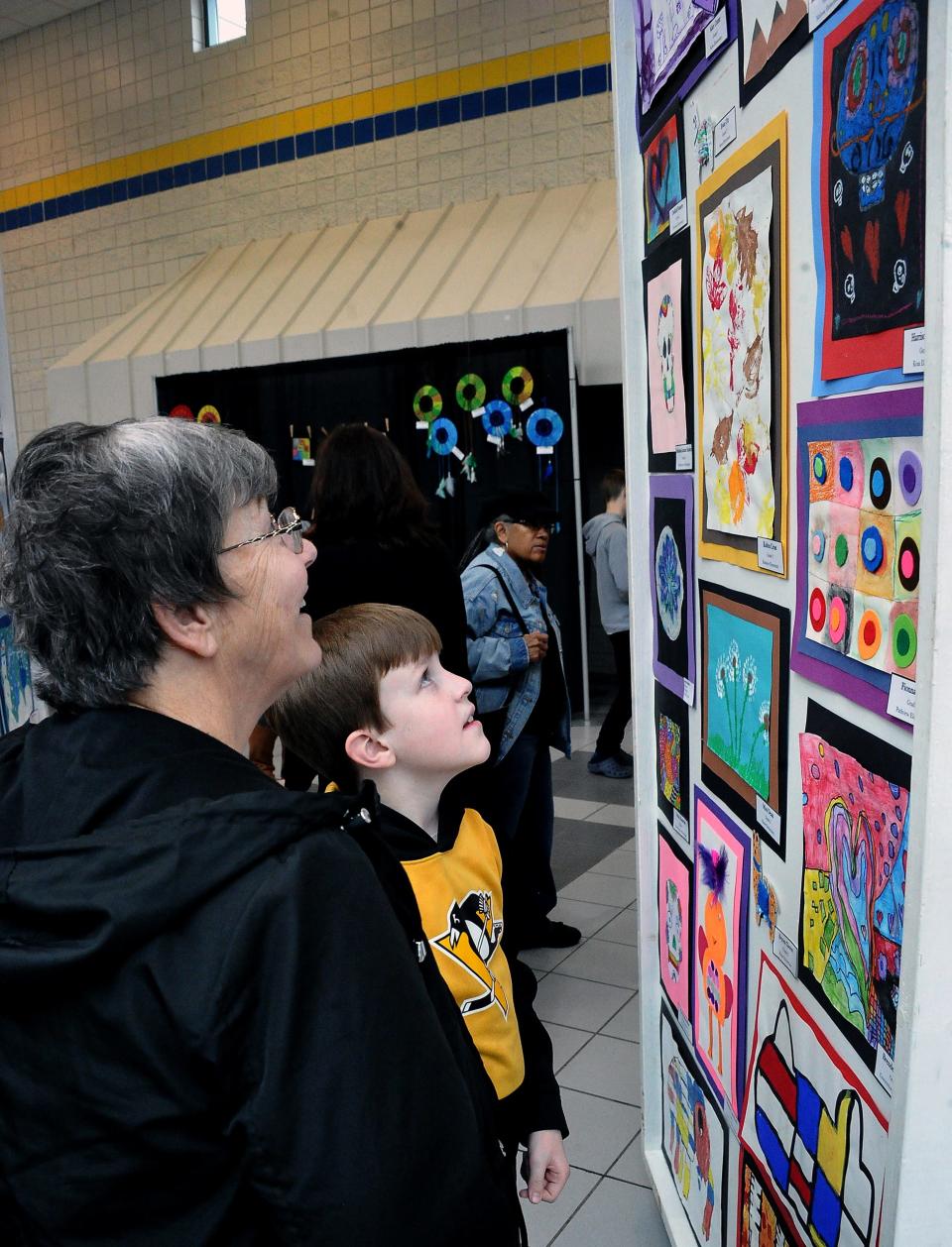 Harrison Sutter shows his grandmother, Lynn West, his painting on display at the 23rd annual Fine Arts Festival at Wooster High.