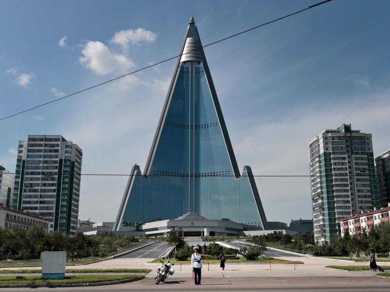 A traffic policeman stands in front of the Ryugyong Hotel in 2019.