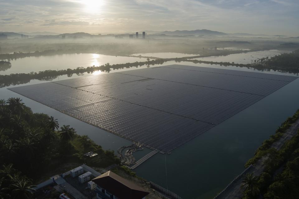 The sun rises over floating solar panels on May 3, 2023, in Selangor, Malaysia. Floating solar panel farms are beginning to boom in the United States after rapid growth in Asia. They're attractive not just for their clean power and lack of a land footprint, but because they also conserve water by preventing evaporation. (AP Photo/Vincent Thian)