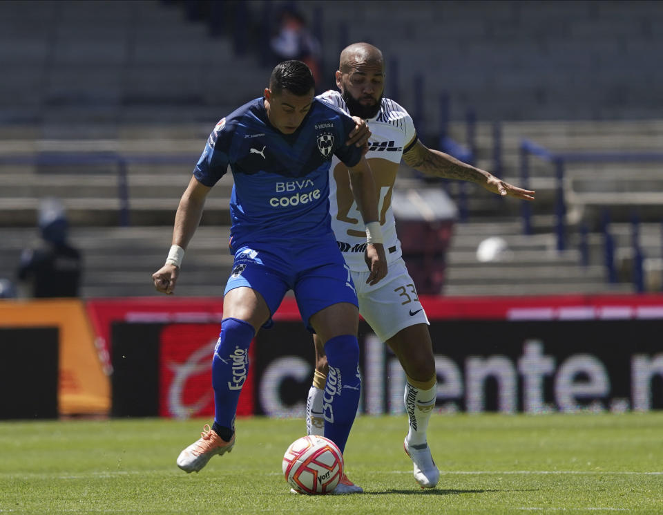 Rogelio Funes Mori (izquierda) del Monterrey y Dani Alves de Pumas pugnan por un balón en el partido de la Liga MX, el domingo 31 de julio de 2022. (AP Foto/Fernando Llano)