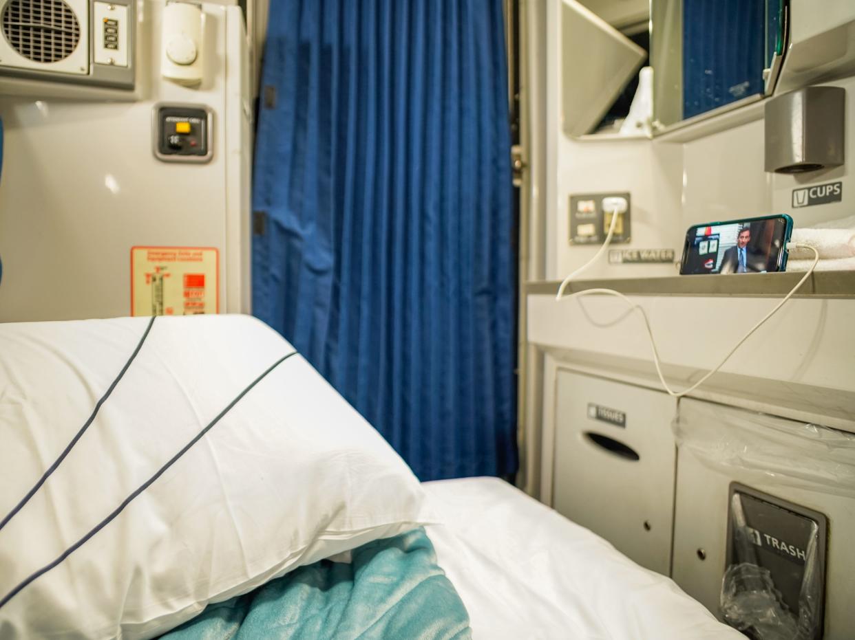 A view of the author's bed set-up, which includes a phone playing "The Office" on the right side.