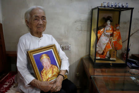 Vietnamese Nguyen Thi Xuan, 94, who married Japanese soldier Nguyen Van Duc during World War Two, poses with a portrait of him at her house in Hanoi, Vietnam February 22, 2017. REUTERS/Kham