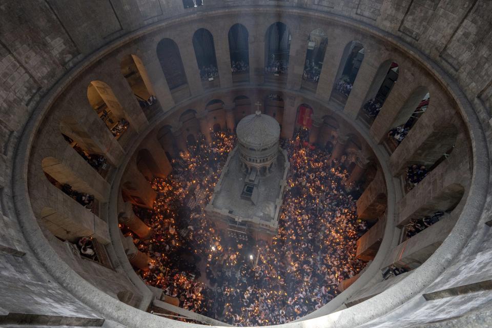 Christian pilgrims hold candles during the Holy Fire ceremony, a day before Easter, at the Church of the Holy Sepulcher, where many Christians believe Jesus was crucified, buried and resurrected, in Jerusalem's Old City, Saturday, May 4, 2024. (AP Photo/Ohad Zwigenberg)