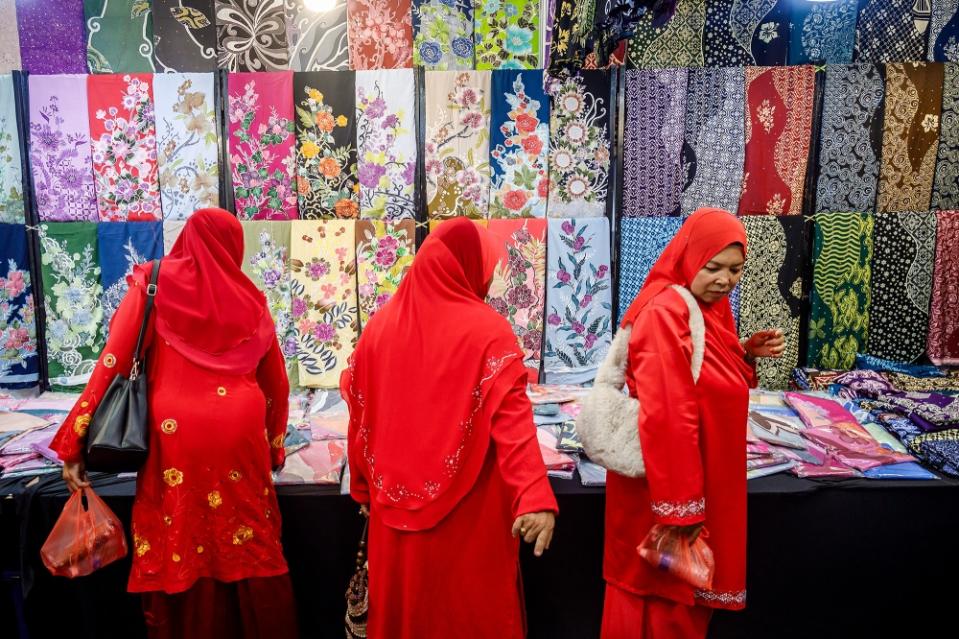 Delegates look at batik offerings at the 2024 Umno General Assembly at the World Trade Center Kuala Lumpur on August 23, 2024. - Film by Firdaus Latif