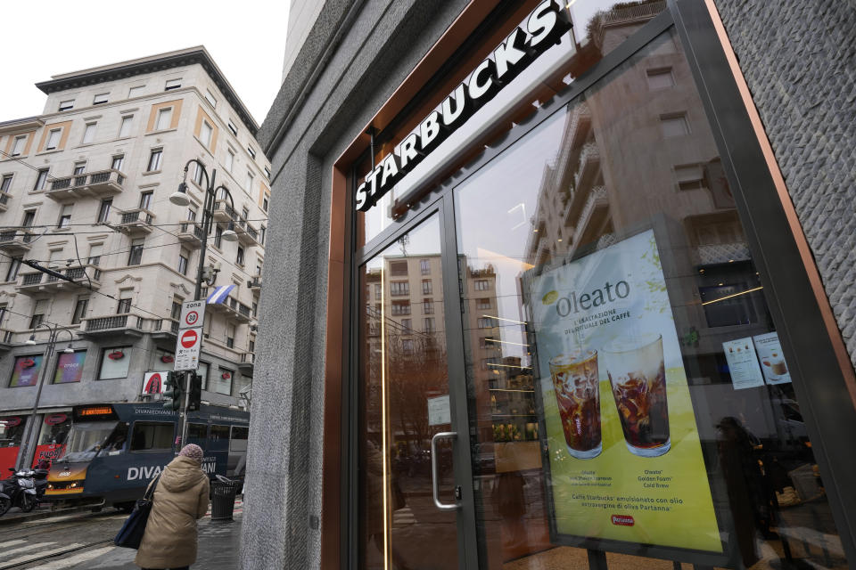 Un letrero que anuncia el café Oleato se destaca en el frente de una cafetería de la cadena Starbucks en Milán, Italia, el lunes 27 de febrero de 2023. Añadir aceite de oliva al café no es una tradición en Italia, pero eso no impidió que Howard Schultz, director general interino de Starbucks, lanzara una serie de bebidas que combinan ambos ingredientes y que actualmente se ofrecen en Milán, la ciudad que inspiró su imperio de cafeterías. (AP Foto/Antonio Calanni)