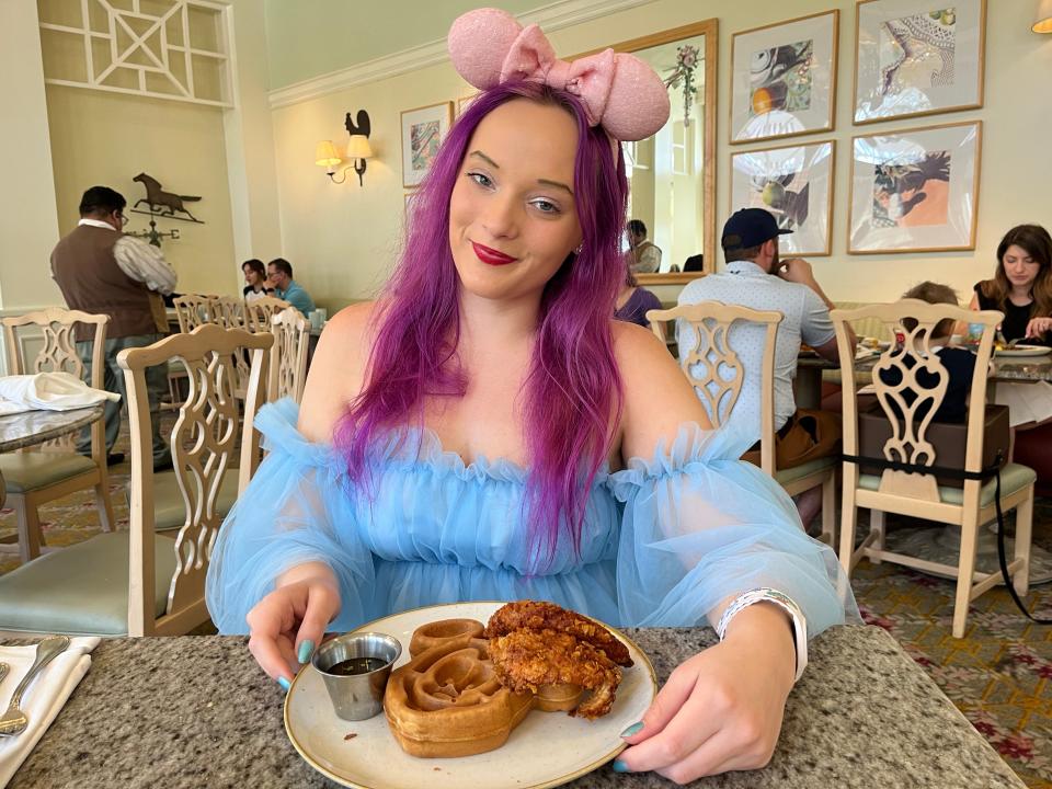 jenna posing with a plate of chicken and waffles from the grand floridian cafe