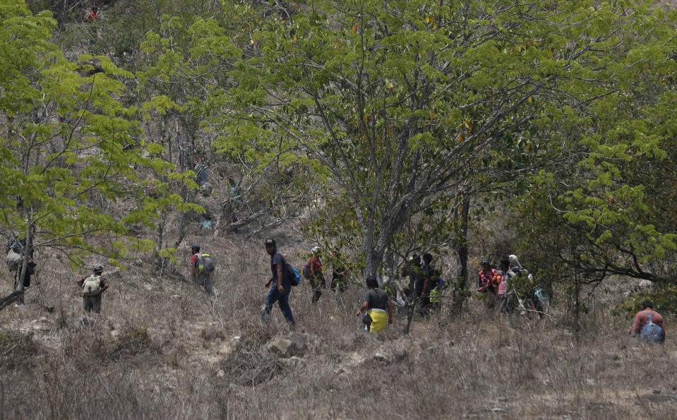 Central American migrants try to evade Mexican immigration agents on the highway to Pijijiapan, Mexico, Monday, April 22, 2019. Mexican police and immigration agents detained hundreds of Central American migrants Monday in the largest single raid on a migrant caravan since the groups started moving through Mexico last year. (AP Photo/Moises Castillo)