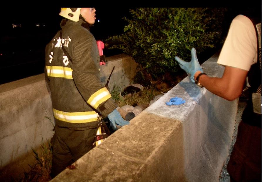 警消發現也有傷者被強大的撞擊甩落至水泥護欄中，趕緊將他救出送醫。（警消提供）