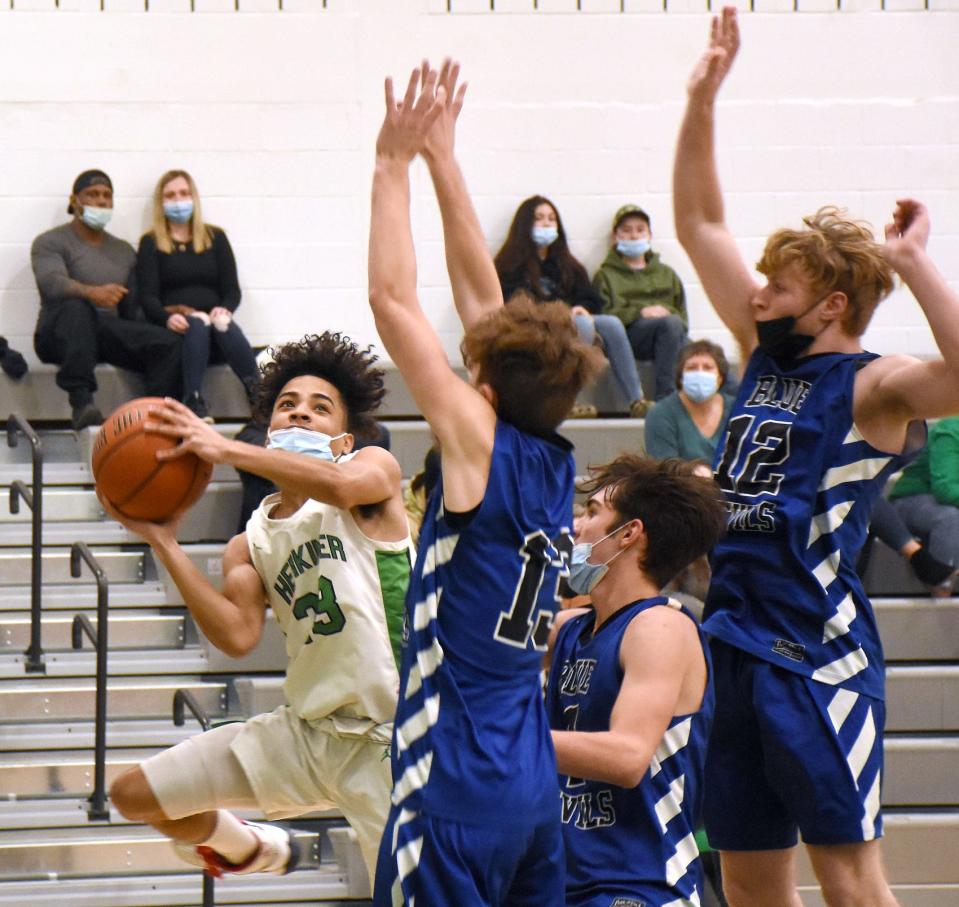 Herkimer's Isaiah Brown (left) tries to get his shot off around a trio of Dolgeville defenders during the first half of Wednesday's basketball game in Herkimer.