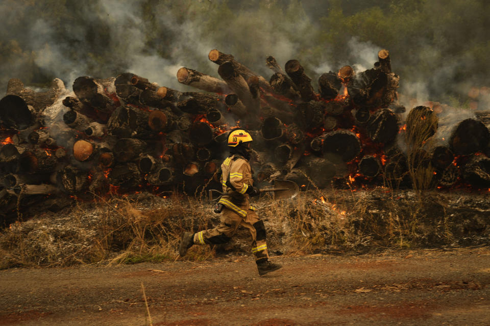 Un bombero corre para combatir las llamas causadas por los incendios forestales en Santa Juana, Chile, el lunes 6 de febrero de 2023. (Foto AP/Matías Delacroix)