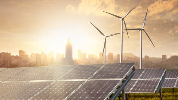 Wind and solar projects with an urban skyline in the background.