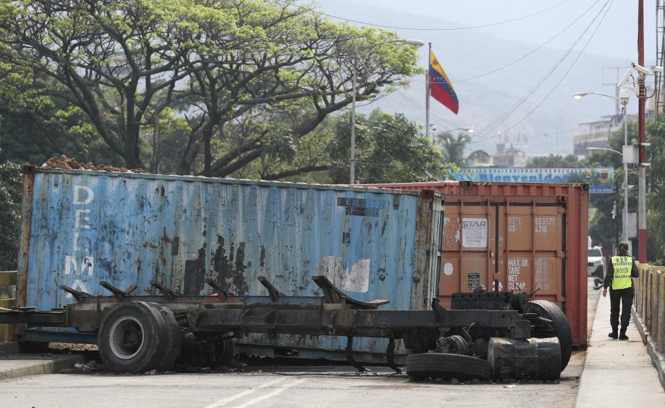 A Venezuelan National Guard walks by containers blocking the Venezuelan side of the Simon Bolivar International Bridge in La Parada, near Cucuta, Colombia, Sunday, March 3, 2019. Last weekend, opposition leader Juan Guaido coordinated a failed effort to bring aid from Colombia and Brazil into Venezuela, where security forces loyal to President Nicolas Maduro blocked the supplies at its border bridges, with Maduro describing Guaido’s gambit as part of a U.S.-backed plot to overthrow him. (AP Photo/Martin Mejia)