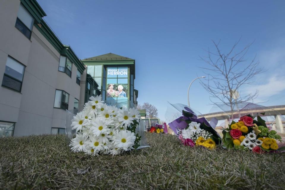 Flowers are placed outside CHSLD Herron in Dorval on Saturday. Thirty-one residents have died at the facility in the past month. The government says at least five of the deaths were linked to COVID-19.