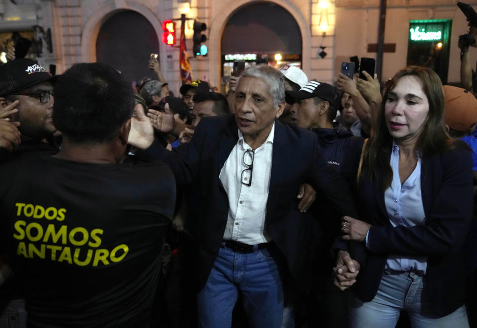 Former Army Maj. Antauro Humala, center, waves to supporters, accompanied by his wife, Ildarina Andrade, as he arrives at Plaza San Martin in Lima, Peru, Saturday, Dec. 10, 2022. Humala, the brother of former President Ollanta Humala, was serving a 19-year sentence for rebellion after taking up arms in 2005 against then-President Alejandro Toledo. (AP Photo/Martin Mejia)