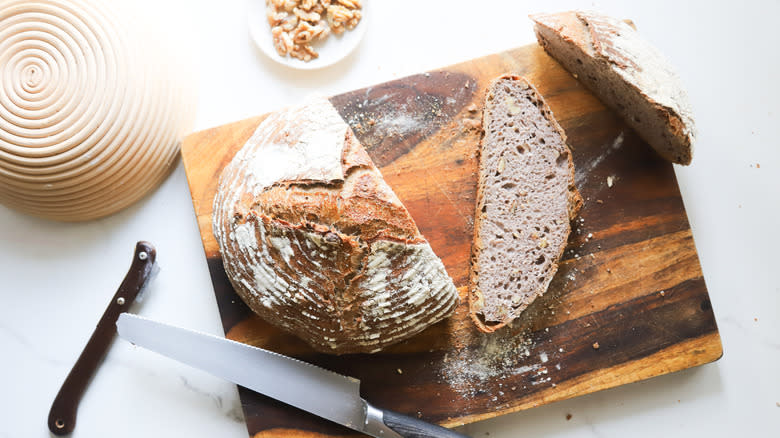 Crusty loaf of walnut bread on cutting board