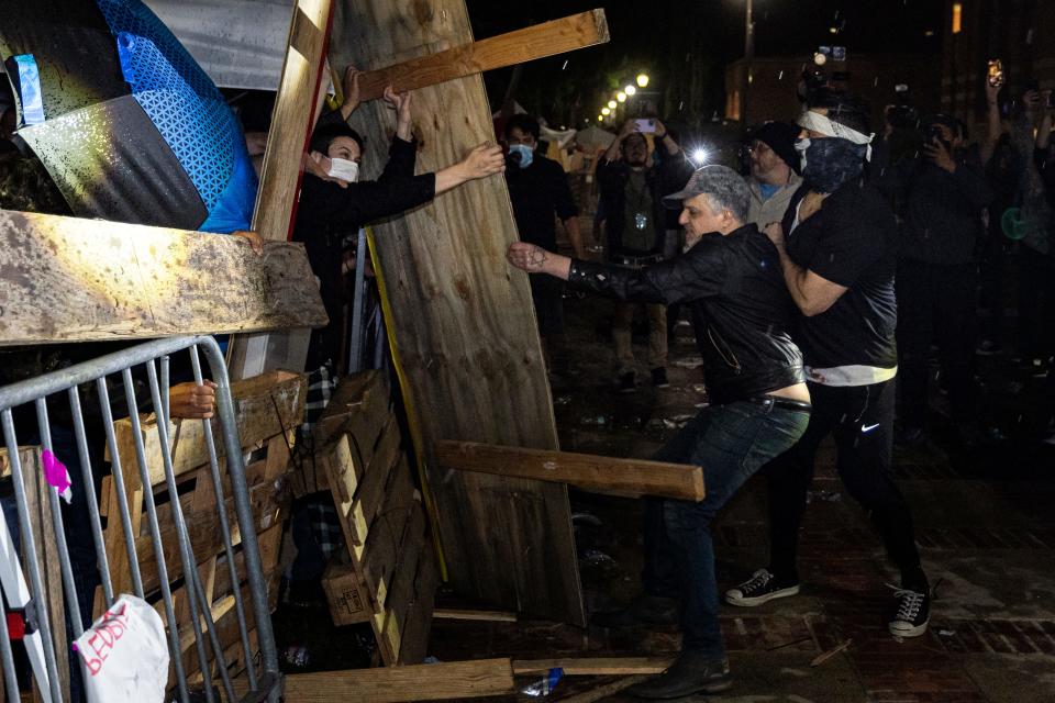 Counter-protesters wearing black attack a pro-Palestinian encampment set up on the campus of UCLA as clashes erupt, in Los Angeles on May 1, 2024.