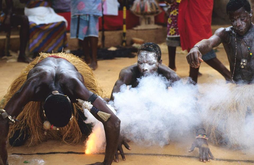 Young men inhale the smoke of gunpowder to show their power in the Kokou Ceremony in Ghana